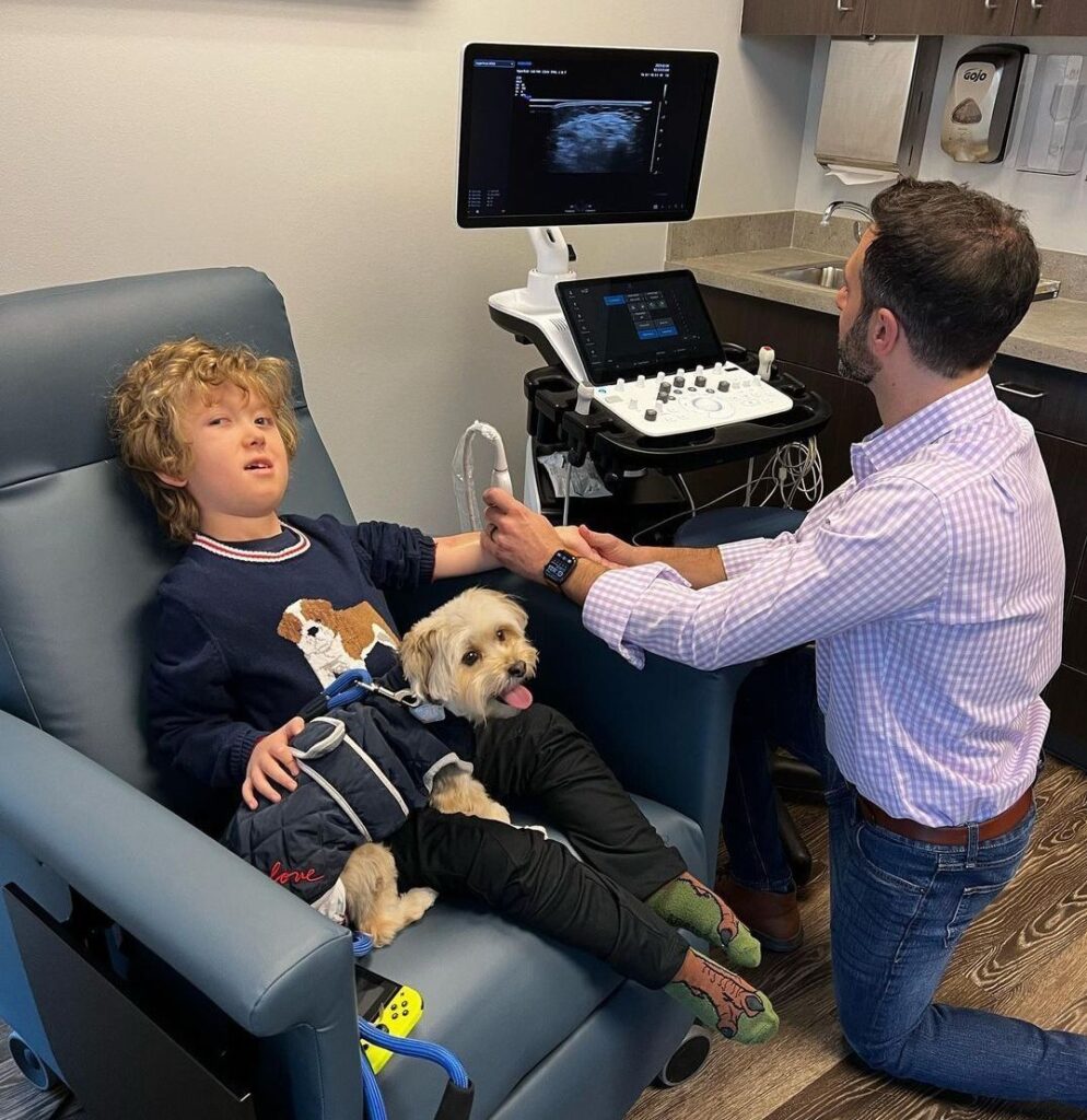doctor with pediatric research patient and dog
