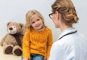 physician with pediatric patient and teddy bear